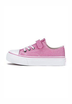 Zapatilla deportiva de lona rosa con suela de goma blanca, diseño con cordones y cierre de velcro. Presenta costuras blancas y una superficie de tejido texturizado.