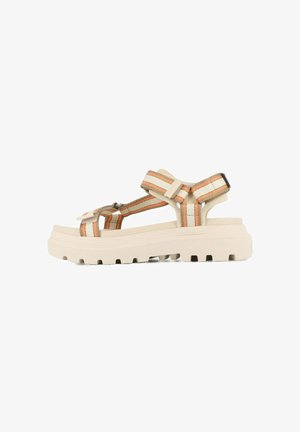 Sandalias de plataforma beige con anchas correas a rayas en naranja y marrón. Cuentan con hebillas ajustables y una suela gruesa y texturizada para mayor agarre.