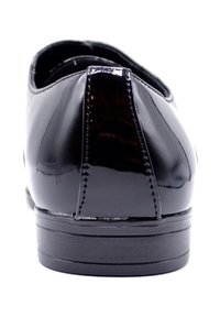 Chaussures en cuir verni noir avec un bout arrondi et un petit talon. Surface lisse et brillante, avec un subtil détail de couture à l'arrière.