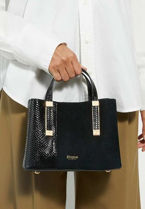 Sac à main noir présentant un mélange de cuir lisse et d'accents de cuir façon serpent texturé, avec des garnitures en ton doré et de courtes poignées.