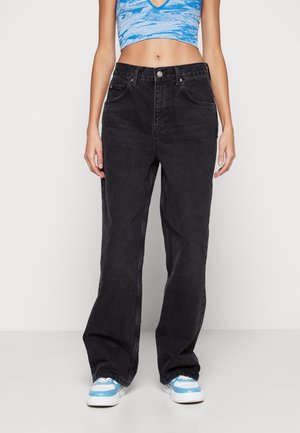 Zwarte denim wijde jeans met vijf zakken, riemlussen en een zilveren knoopsluiting; gecombineerd met een blauwe cropped top en sneakers.