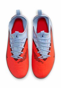 Baskets de sport rouge et bleu clair avec une tige texturée, fermeture à lacets et côtés ventilés, présentant un logo noir sur le bord extérieur.