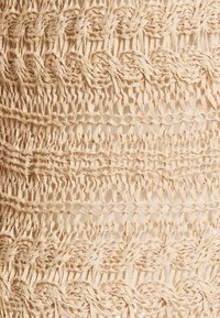 Beige crocheted fabric with a textured pattern, featuring repeating intertwined designs and open mesh sections. Soft, thin yarn.