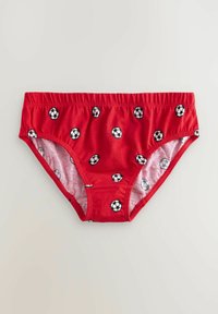 Mutandine rosse per bambini con un elastico in vita e un motivo di palloni da calcio neri e bianchi. Realizzate in morbido tessuto di cotone.