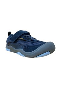 Zapatilla deportiva azul marino con parte superior de malla, acentos de ante, tiras de Velcro y suela de goma gris con fondo azul para mejor agarre.
