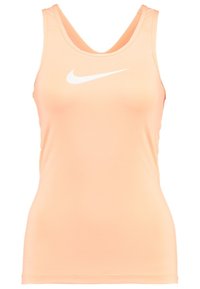 Brzoskwiniowy top na ramiączkach Nike wykonany z gładkiego, elastycznego materiału. Charakteryzuje się głębokim dekoltem w kształcie litery V oraz białym logo Nike w kształcie smugi z przodu.