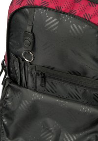 Černý batoh uvnitř s různými velikostmi kapes, s texturovaným potiskem geometrických vzorů v šedé barvě. Obsahuje klíčenku a zipy.