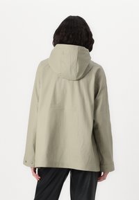 Veste extérieure gris clair avec capuche, manches larges et boutons-pression aux poignets. Texture lisse avec un design décontracté.