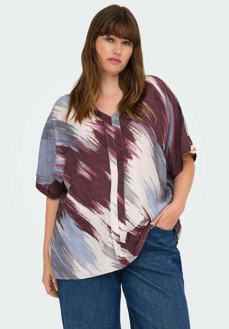 Blouse surdimensionnée en tissu léger avec un motif tie-dye bordeaux, bleu et gris, dotée d'un col en V et de manches courtes.