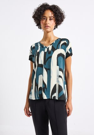 T-shirt à manches courtes avec un col en V, présentant un motif abstrait teal, noir et crème. Fabriqué en tissu léger avec une coupe loose.