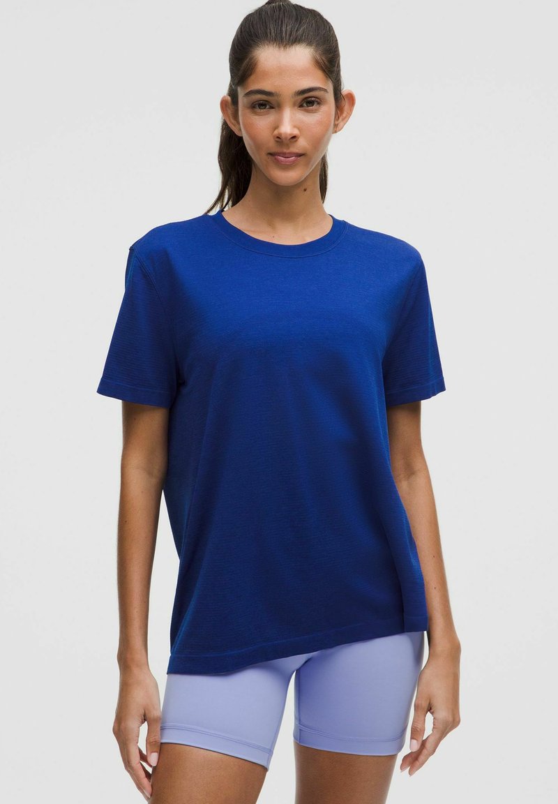Kurze, blaue T-Shirt aus weichem Stoff, mit lockerer Passform und rundem Ausschnitt, kombiniert mit helllila Sportshorts.