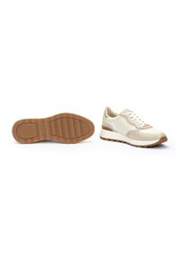 Zapatillas deportivas beige y crema con tejido texturizado, cuello acolchado y suela de goma con un patrón de olas y talón reforzado.