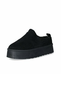 Scarpe slip-on nere in suede texturizzato, con una suola in gomma spessa e un design a punta tonda. Stile minimalista senza hardware visibile.