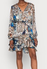 Sukienka z długim rękawem z lekkiego materiału z mixem wzorów paisley, kwiatowych i w panterkę w odcieniach niebieskiego i neutralnych. Falbaniasty dół i wiązanie w talii.