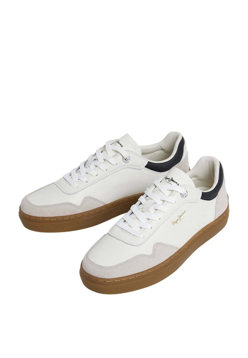 Weiße Sneakers mit einer beigen Wildlederspitze, schwarzem Fersenelement und brauner Gummisohle. Sie verfügen über weiße Schnürsenkel und ein dezentes Logodetail an der Seite.