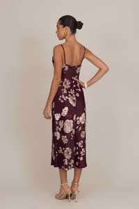 Robe slip bordeaux à fleurs avec des bretelles fines, longueur mi-mollet, texture satinée, ornée de grandes fleurs crème et roses, et une silhouette ajustée.