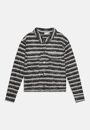 Cropped košulja sa crno-belim prugama, izrađena od teksturiranog materijala, sa okovratnikom i dugmadima koja se nalaze sprijeda. Uključene duge rukave.