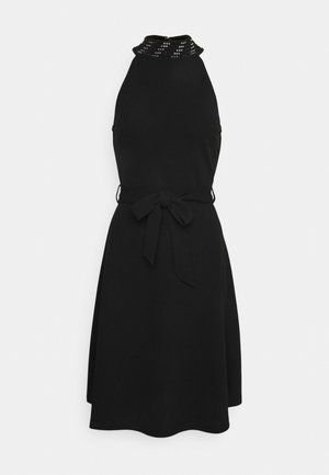 Vestido preto com um corpete justo, gola alta com tachas prateadas e saia fluida. Inclui um cinto atado na cintura. Textura suave.