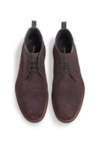 Chaussures violettes foncées texturées avec une finition lisse, dotées de lacets en cuir, de coutures discrètes et d'une semelle marron.