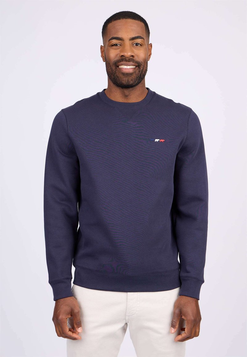 Sweatshirt marine avec un col rond côtelé et des manches longues. Présente un petit design graphique multicolore sur la poitrine. Texture lisse.