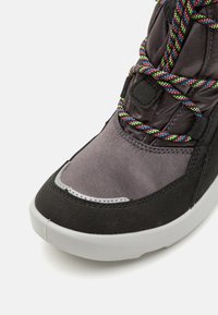 Schwarze und graue Sneaker mit einer strukturierten Oberseite, mehrfarbigen Schnürsenkeln und einer weißen Gummisohle mit einem abgerundeten Zehenbereich.