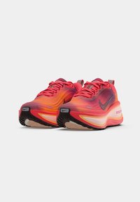 Nike tenisice za trčanje sa gradijentnim dizajnom u nijansama ružičaste i narančaste, teksturiranim mrežastim gornjim dijelom i crnim gumiranim potplatom s Zoom brendingom.