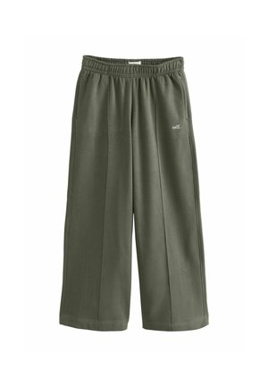 Green wide-leg pants with elastic waistband and side pockets, featuring small white "self." text on the right thigh.