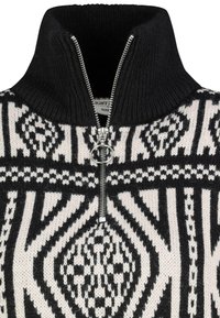 Strickpullover mit hohem Kragen, schwarz-weißer geometrischer Musterung, Reißverschluss und strukturiertem Stoff. Mit einem silbernen Ring-Reißverschlussanhänger.