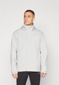 Chubasquero impermeable gris claro con un cuello alto, capucha ajustable y detalle del logo. Presenta una textura suave y un diseño práctico.