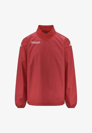 Giacca a vento rossa con colletto alto, maniche lunghe e polsini elastici. Presenta un logo bianco sul petto e sulla spalla. Texture liscia.