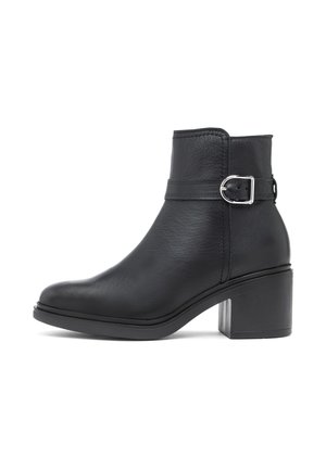 Schwarzer Lederknöchelstiefel mit Blockabsatz und einem silbernen Schnallenriemen um den oberen Teil des Schuhs.