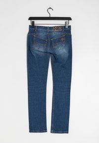 Blå denimjeans med standardpassform, fem fickor, ljus sömnad och en texturerad etikett på baksidan av midjebandet.