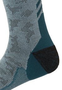 Calcetín texturizado en tonos teal y gris con talón gris oscuro. Presenta un patrón de formas estilizadas en negro sobre una tela ligera y transpirable.