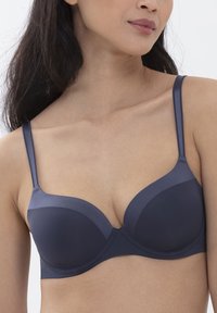 Marineblauer unterfütterter BH mit glatten, geformten Schalen und verstellbaren Trägern. Konturierte Form, nahtloses Design und weiche Textur.