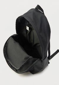 Must seljakott sileda tekstuuriga ja tõmblukuga sulgumisega. Sisemus nähtav, sisaldab vooderdatud sektsiooni ja riputatavat sildikest.