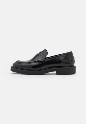 Mocassin penny en cuir noir avec bout arrondi, finition brillante et petit talon sur fond blanc uni.