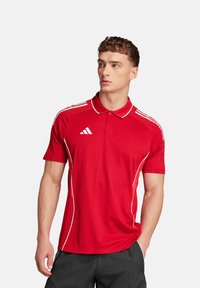 Rode polo shirt met witte strepen langs de schouders en zijkanten. Beschikt over een kraag en een geborduurd logo op de borst. Gladde textuur.