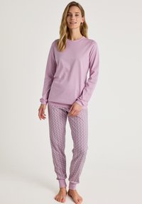 Lila lange mouwen pyjama top gecombineerd met gestreepte pyjamabroek met een bloemenpatroon in pastelkleuren. Zachte stof met geribde manchetten.