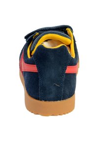 La sneaker presenta una toma superior in suede blu navy con accenti rossi, un colletto padroneggiato giallo e una suola in gomma liscia. Cinturino in velcro sul tallone per un supporto extra.
