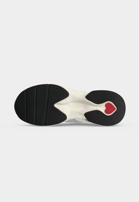 Σόλα από αθλητικό παπούτσι με μαύρο πέλμα και κόκκινη καρδιά κοντά στη φτέρνα σε λευκό φόντο.