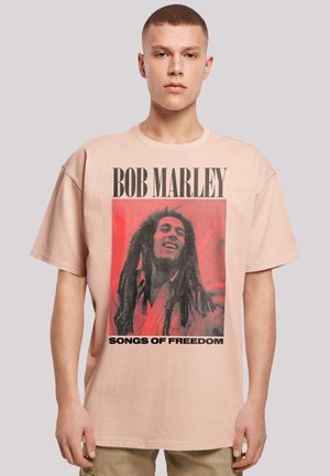 Rosa Baumwoll-T-Shirt mit einem großen Grafikdruck von Bob Marley und dem Text "SONGS OF FREEDOM" in Schwarz. Lockere Passform und kurze Ärmel.