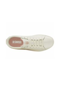 Baskets en cuir blanc avec un bout rond, surface texturée, système de laçage et semelle intérieure rose, arborant le logo "K-Swiss" sur la languette.