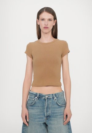 Brown ribbed short-sleeve top with a round neckline, cropped design, paired with high-waisted light blue wide-leg jeans.