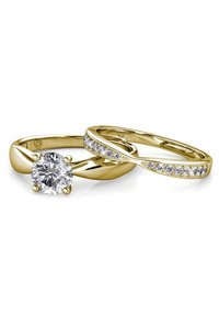 Set di fedi nuziali in oro con un anello solitario che presenta un grande diamante rotondo e una fascia curva con diamanti più piccoli lungo la parte superiore.