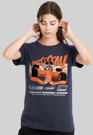 Young person wearing a navy T-shirt with an orange race car and text "VROOOOM! Torque Racing League" in a graphic design.