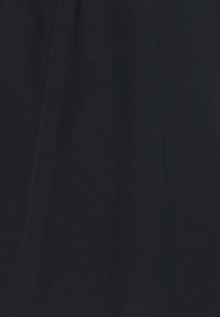 Tissu noir avec une texture lisse et mate. La surface est uniforme, avec des plis subtils suggérant un matériau léger. Aucun motif ou accent notable.