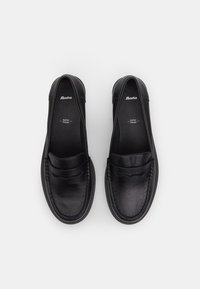 Black leather loafers featuring a moccasin stitch, slip-on design, with a smooth texture and minimalistic accent on the upper.