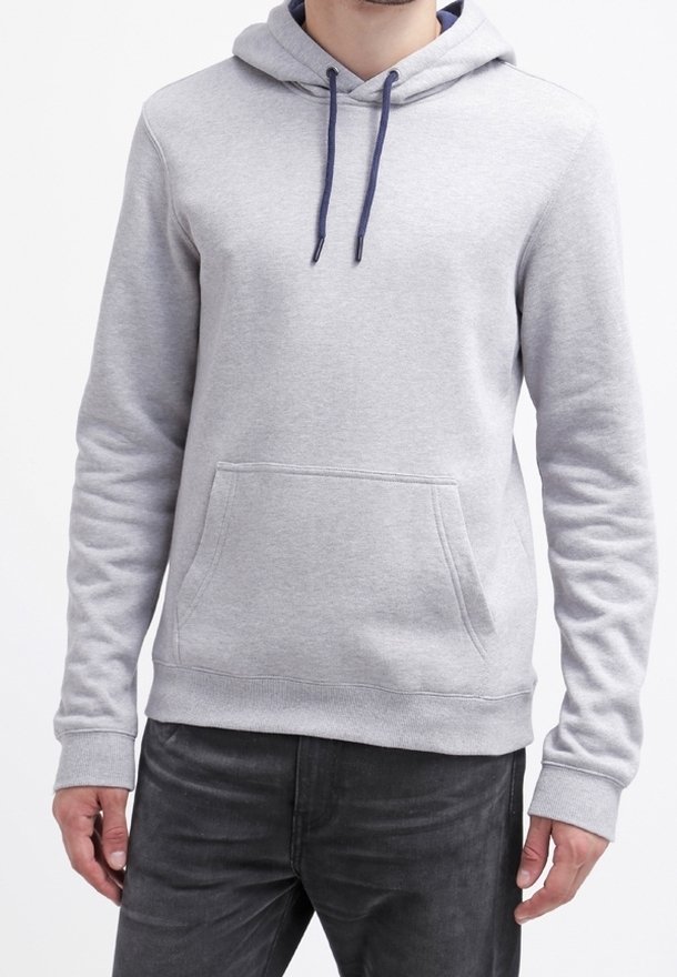 Mand iført en lysegrå hættetrøje med frontlomme og marineblå snore, kombineret med mørkegrå jeans, stående mod en hvid baggrund.