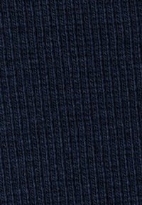 Tejido acanalado de navy oscuro con un patrón texturizado de líneas verticales, adecuado para prendas de vestir o tapicería.