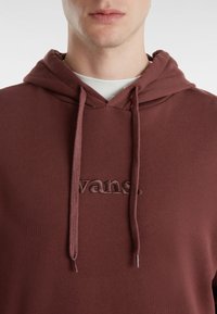 Felpa con cappuccio marrone scuro realizzata in un tessuto testurizzato, con logo "vans." ricamato. Dotata di stringhe e di un classico design con tasca a canguro.